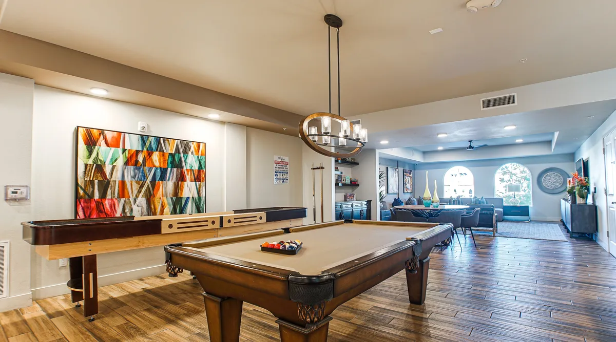 A lively interior communal space featuring a pool table, colorful artwork, and a seating area with a couch. The area invites socializing, play, and relaxation for both families and groups, further underscoring the flexibility and entertainment options available within the property.